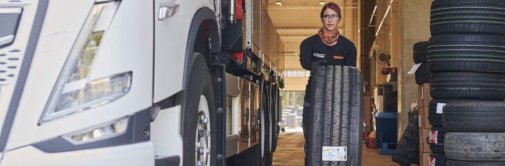 kvinna byter hjul och däck på lastbil