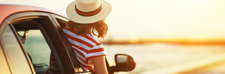 happy woman girl goes to summer travel trip in car